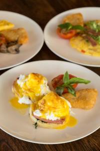 three plates of food on a table with eggs and toast at Jeeva Klui Resort in Senggigi