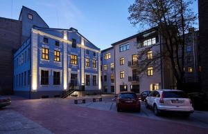 een gebouw waar auto's voor geparkeerd staan bij Ex Factory apartment in Rīga
