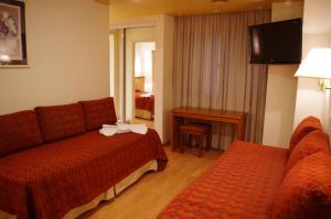 Habitación de hotel con sofá y mesa en Hotel Felipe II en Córdoba