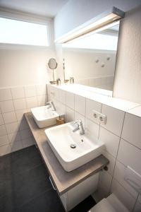 a bathroom with two sinks and a mirror at Deichhaus Brisinga in Breege