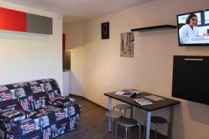 a room with a couch and a table and a tv at Cimes De Caron Appartements VTI in Val Thorens