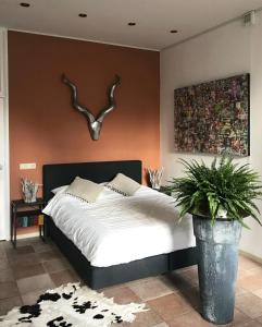 een slaapkamer met een bed en een muur met geweien bij De Pelgrimsplaats in Leiden