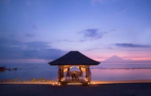 a group of people sitting in a gazebo on a beach at Jeeva Klui Resort in Senggigi