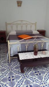 a bedroom with a bed with a table in it at Blue Bab B&B in Lampedusa
