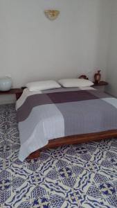 a bedroom with a bed with a blue and white floor at Blue Bab B&B in Lampedusa