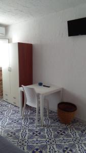 ランペドゥーザにあるブルー バブ B＆Bの白いテーブルと椅子が備わるタイルフロアの客室です。