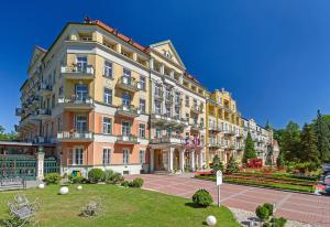 un grand bâtiment avec une pelouse devant lui dans l'établissement Spa Resort PAWLIK-AQUAFORUM, à Františkovy Lázně