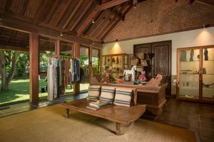 a living room with a wooden table and a store at Jeeva Klui Resort in Senggigi