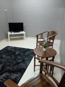 a living room with two chairs and a table and a tv at Taman Tanjung Minyak in Melaka