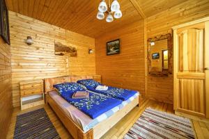 1 dormitorio con 1 cama en una cabaña de madera en Villa U Tsymbora, en Sinyak