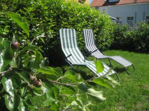 deux chaises assises dans l'herbe dans une cour dans l'établissement Pension Waldrose, à Sellin