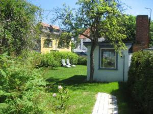 un patio con una casa y un árbol en Pension Waldrose, en Ostseebad Sellin