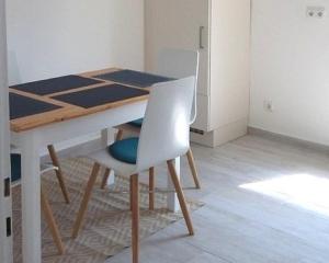 a dining room table with two white chairs and a table at Ferienwohnung Hofgarten in Ansbach