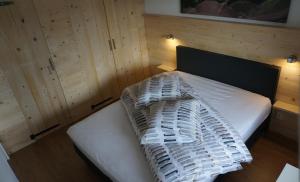 Un dormitorio con una cama blanca con paredes de madera. en Appartement Familie Willems Winterberg 2, en Winterberg