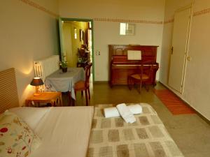 um quarto com uma cama, um piano e uma mesa em damario panorama em Panzano