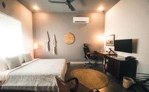 a bedroom with a bed and a desk and a television at iRoHa Garden Hotel & Resort in Phnom Penh