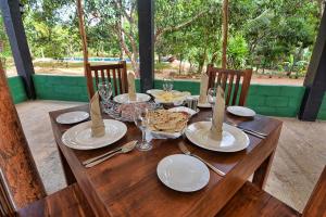 a wooden table with plates of food on it at Dambulla Hills Resort in Dambulla