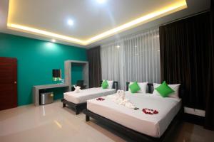 two beds in a room with green walls at The Aireen Hotel in Ao Nang Beach