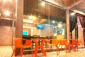 a group of orange chairs and a table in a restaurant at The Aireen Hotel in Ao Nang Beach
