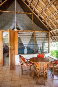 uma sala de jantar com mesa e cadeiras em Capricorn Beach Cottages em Pangani