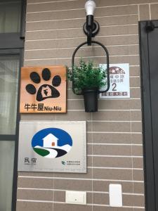 un muro con dei cartelli e una pianta in vaso. di Moo House a Dayin