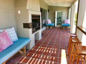 a porch with blue benches and a tiled floor at Seabreeze in Kommetjie