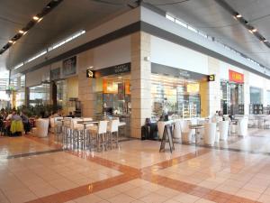 a shopping mall with tables and chairs and people at Chopin Apartments - Platinum Towers in Warsaw