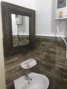uma casa de banho com um lavatório e um espelho em The Mountain View Hat Sai Ri Resort em Chumphon