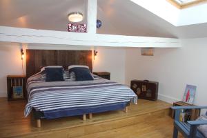 una camera da letto con un letto con un orologio sul muro di La Belle Vie Capbreton a Capbreton