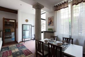 una sala da pranzo con tavolo, sedie e colonna di Charming Navigli a Milano