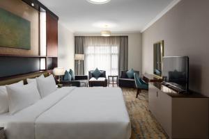 um quarto de hotel com uma cama grande e uma sala de estar em Saja Al Madinah em Medina
