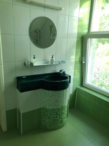 baño con lavabo negro y espejo en Pensiunea Catering Bio Concept SRL, en Mărăcineni