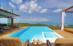 a swimming pool with chairs and a view of the ocean at 7 Bedroom Sea Blue View Villa SDV080C - 5 Star with Staff-By Samui Dream Villas in Bophut 