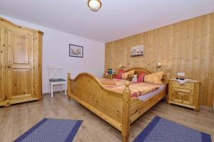 una camera con un grande letto in legno di Haus Meinecke a Bad Hindelang