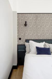 a bedroom with a large white bed with a headboard at Joie Paris Opéra - Gare St Lazare in Paris
