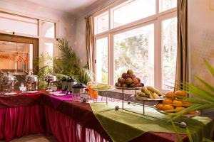 a table with a bunch of fruits on plates at Hotel Buddha Castle in Varanasi