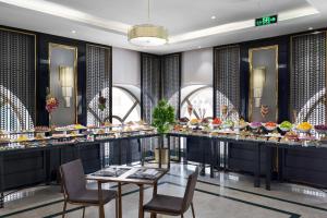 a dining room with a buffet of food at SAJA By Warwick Madinah Hotel in Medina