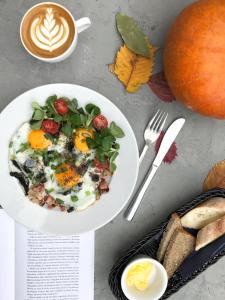 a table with a bowl of breakfast food and a cup of coffee at Bed&Bath Luxury Apartments in Krakow