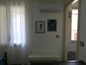 a white room with a window and a bench at Akron B&B in SantʼAlessio Siculo