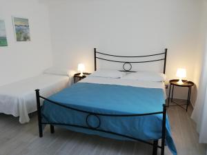 a bedroom with a large bed with a blue blanket at Akron B&B in SantʼAlessio Siculo