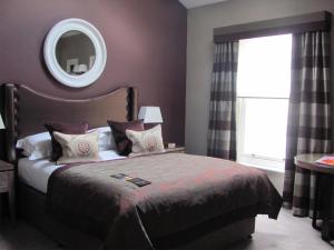 a bedroom with a bed with a mirror on the wall at Macdonald Windsor in Windsor