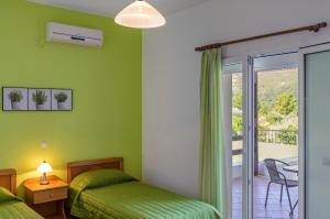 1 dormitorio con 2 camas y balcón en Mouzakis Villas, en Agía Paraskeví
