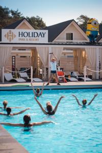 a group of people swimming in a swimming pool at Holiday Park & Resort Grzybowo in Grzybowo