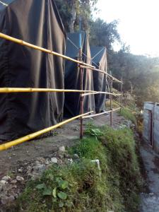 un groupe de tentes est enveloppé dans de la tare noire dans l'établissement Dalhousian camping⛺⛺⛺⛺, à Dalhousie