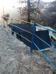 une clôture sur le côté d'une montagne dans l'établissement Dalhousian camping⛺⛺⛺⛺, à Dalhousie