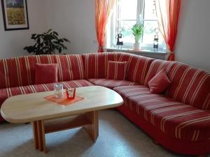 a red couch with a coffee table in a living room at Beautiful Apartment in Morscheid Riedenburg in Morbach