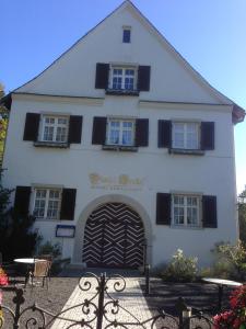 ein weißes Gebäude mit einem großen Tor davor in der Unterkunft Hotel/Restaurant Nicolai Torkel in Konstanz