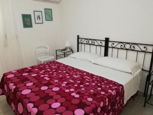 a bedroom with a bed with a red and pink blanket at Akron B&B in SantʼAlessio Siculo