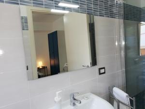 a bathroom with a sink and a mirror at Akron B&B in SantʼAlessio Siculo