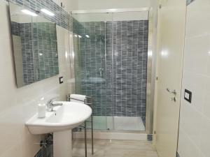 a bathroom with a sink and a glass shower at Akron B&B in SantʼAlessio Siculo